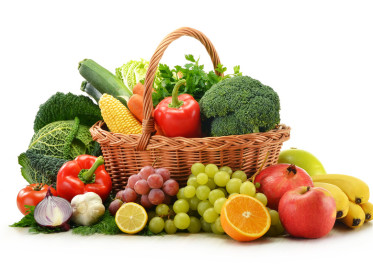 Composition with vegetables and fruits in wicker basket isolated on white